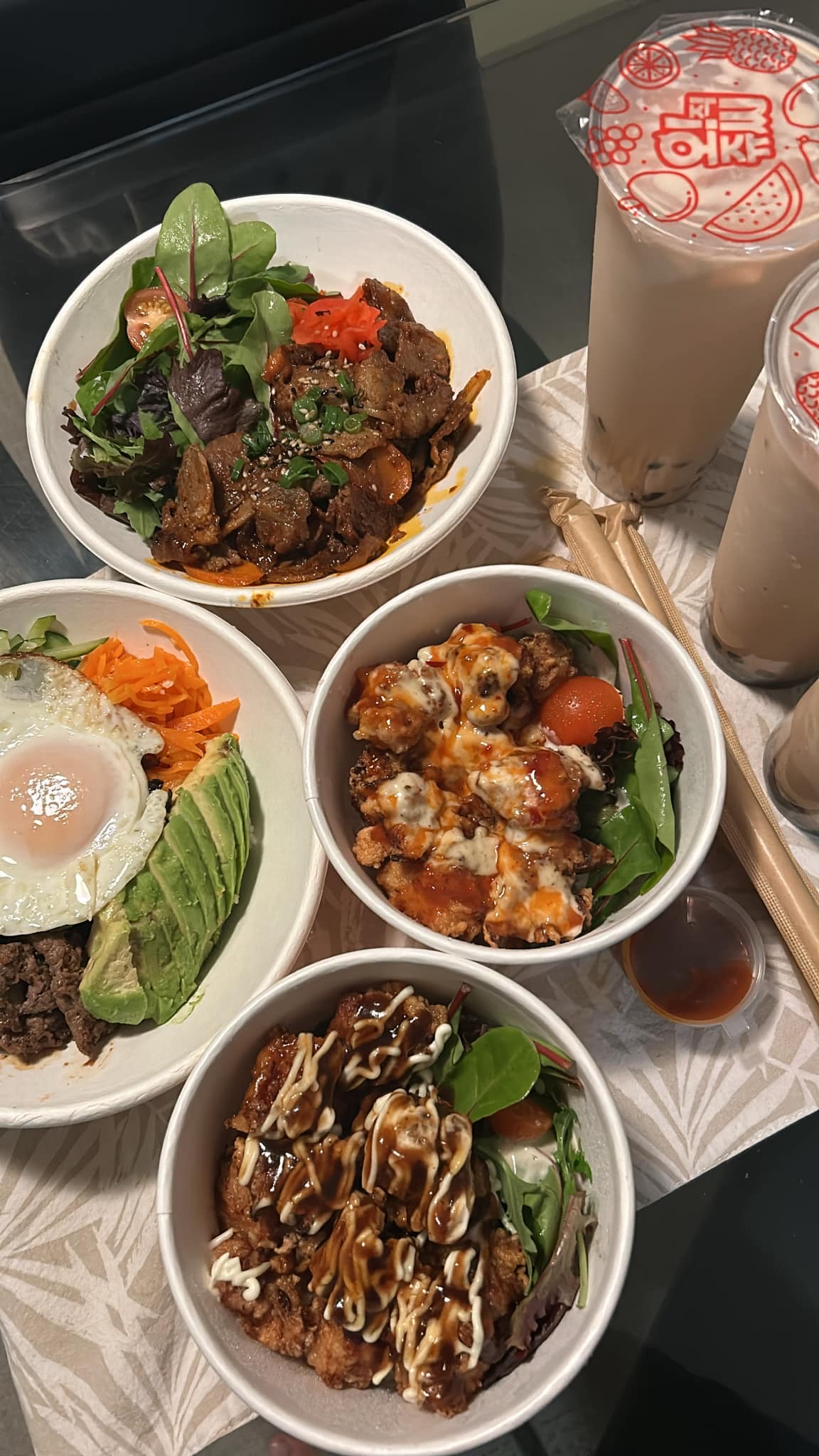Four rice bowls including beef bulgogi, honey chilli chicken and teriyaki chicken, with bubble tea